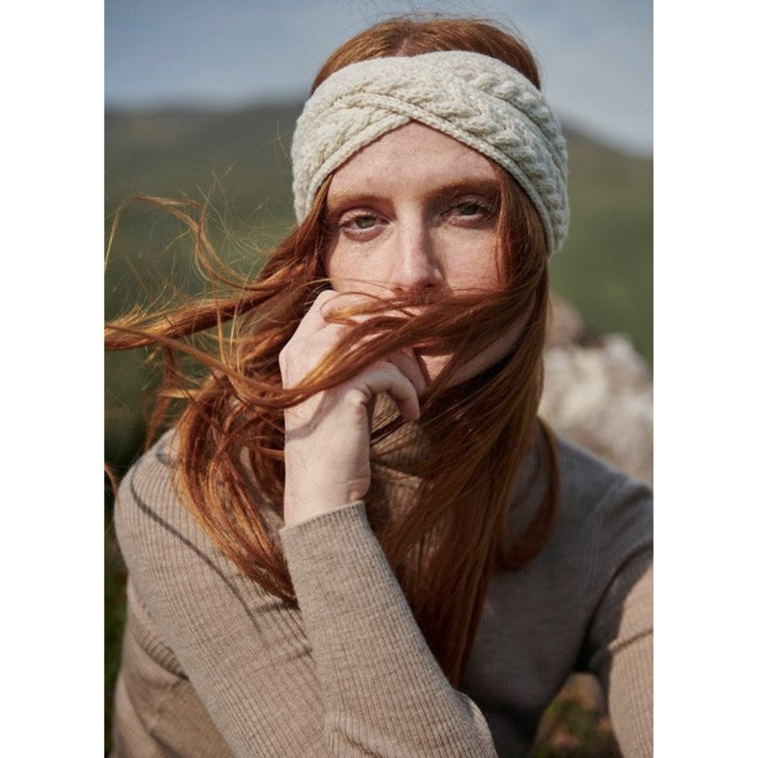 Woman with red hair wearing knitted headband and sweater outdoors