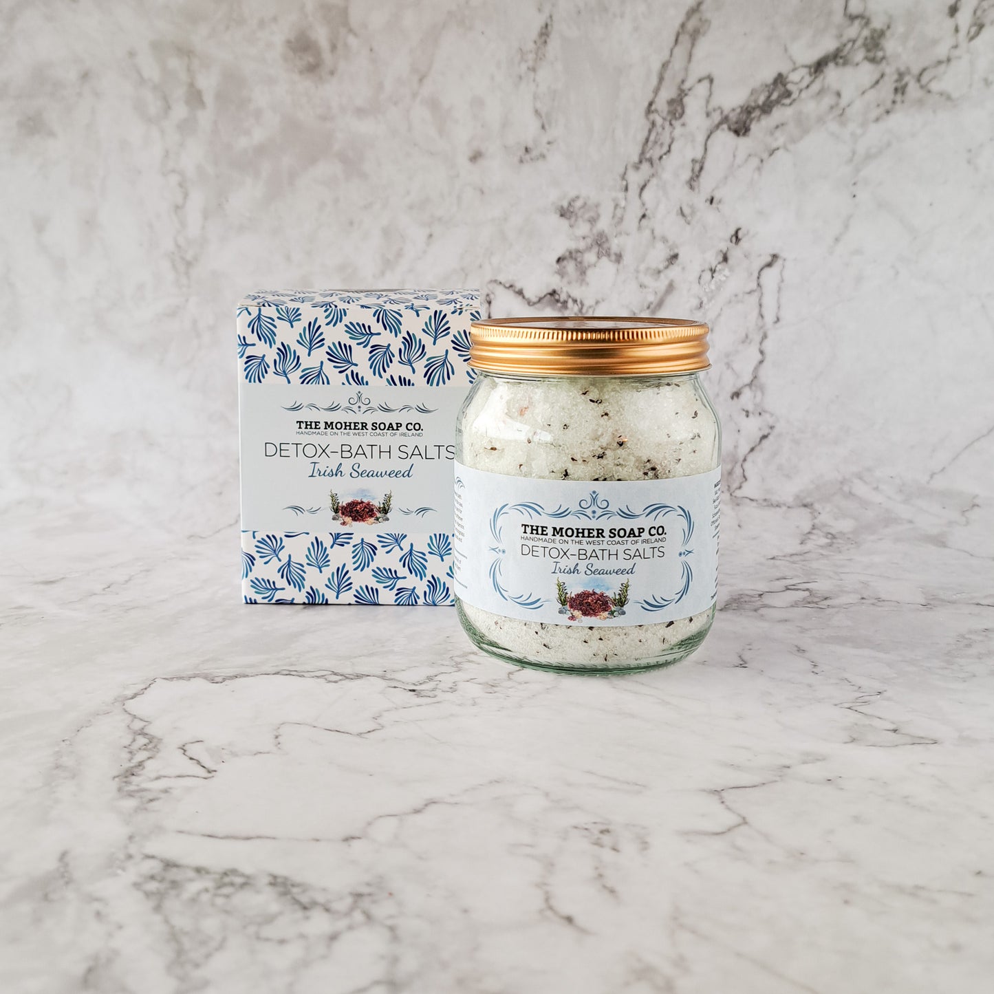 Jar of Detox Bath Salts Irish Seaweed beside a blue patterned box on a marble surface