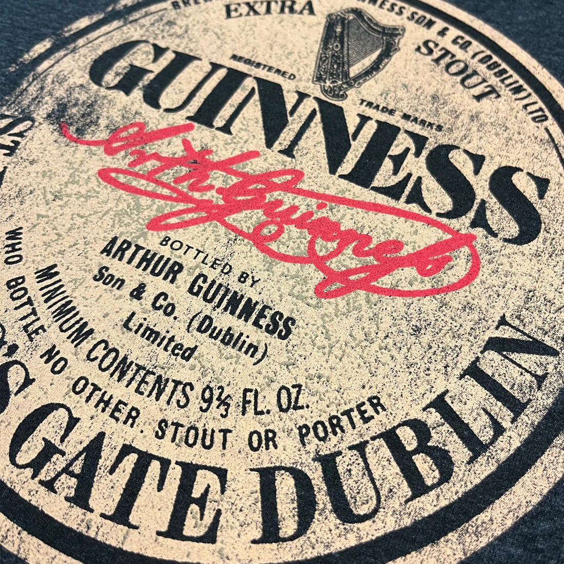 Close-up of vintage Guinness label with red signature and text details
