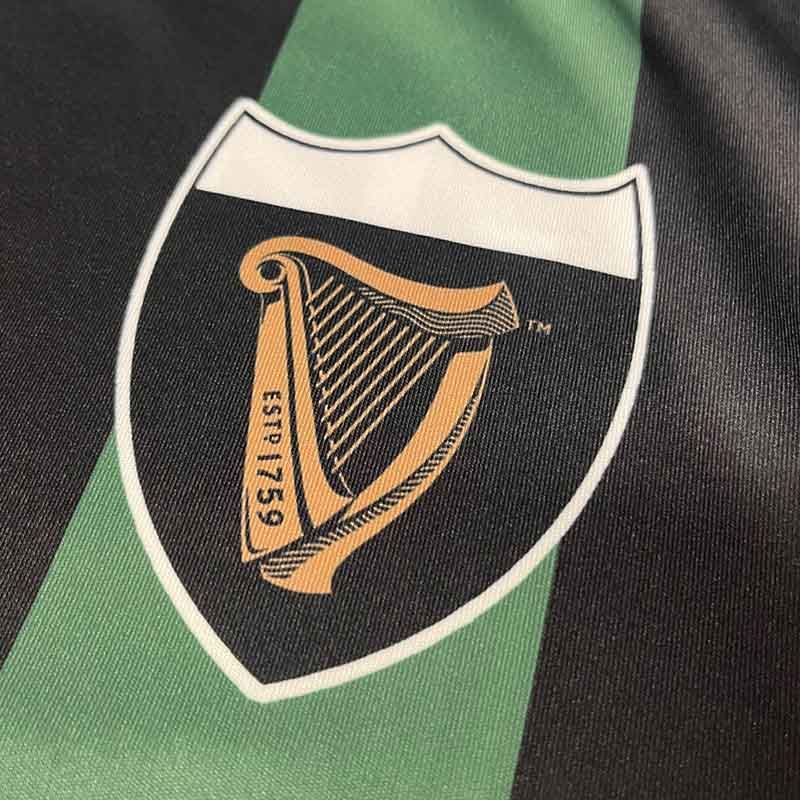 Close-up of a black and green fabric with a gold harp emblem