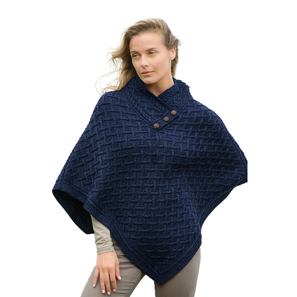 Woman modeling a navy blue merino poncho with a chunky knit pattern and shoulder buttons