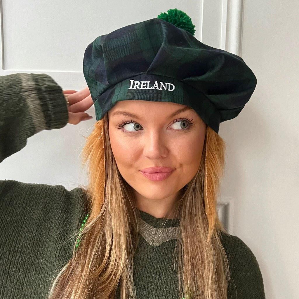 Young woman wearing a green plaid beret with Ireland embroidered