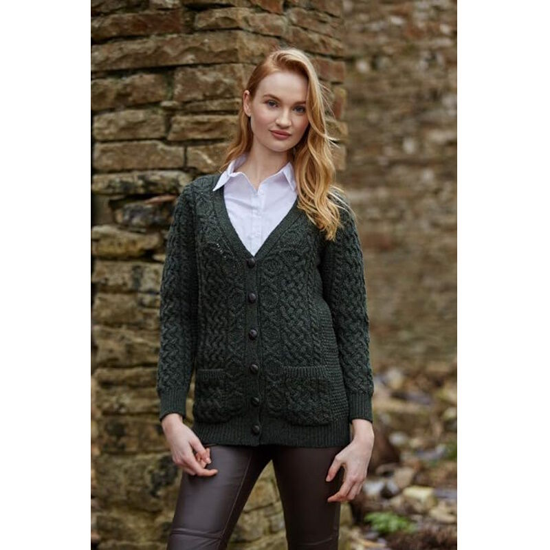 Woman wearing dark green knitted cardigan and white shirt standing outdoors