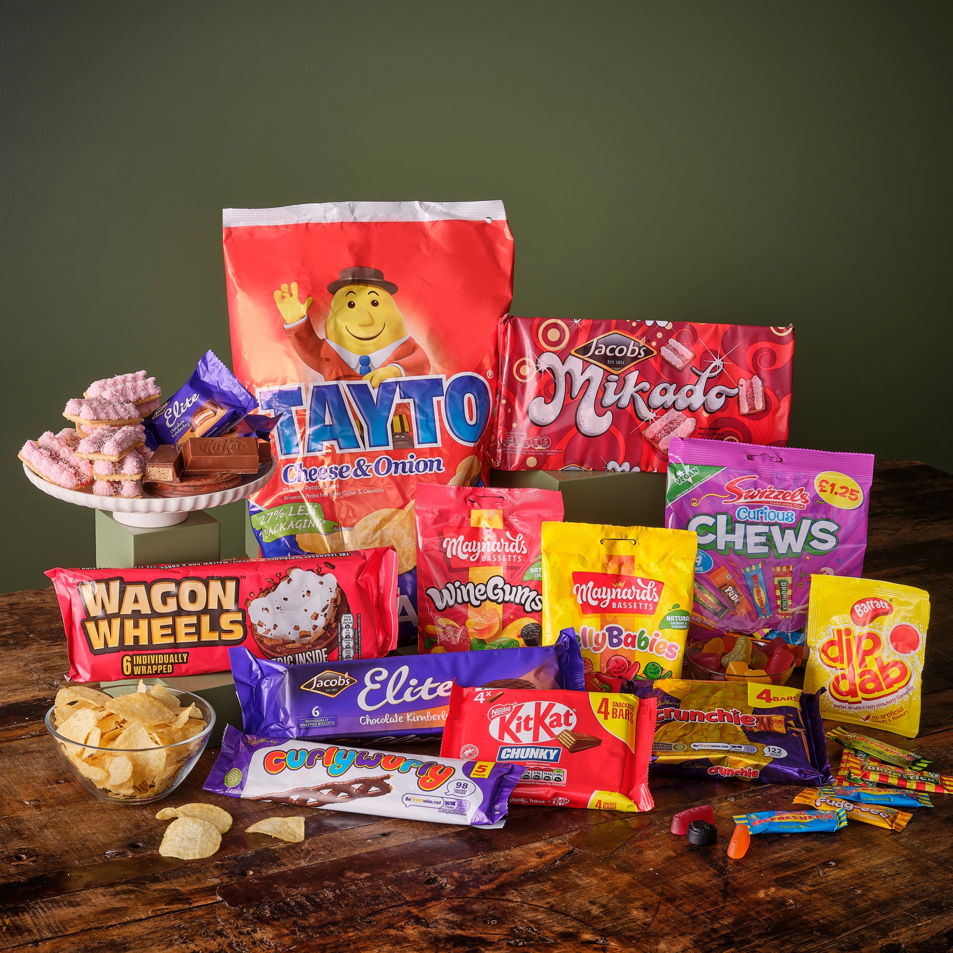 Assortment of colorful packaged snacks and sweets on wooden surface