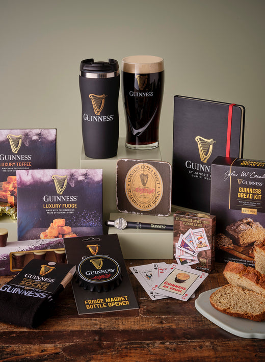 Assortment of Guinness branded products including snacks, socks, and a pint glass