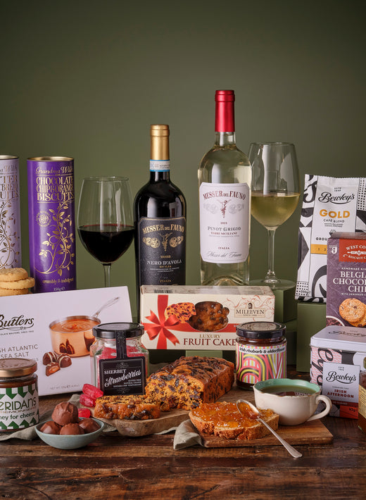 Assorted holiday treats with wine, biscuits, chocolates, and festive decorations
