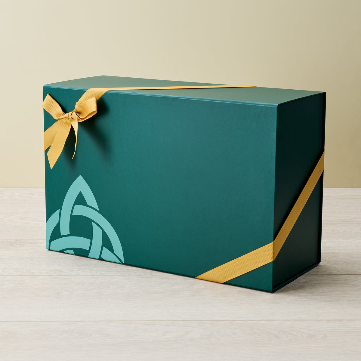 Teal rectangular gift box with yellow ribbon and geometric design