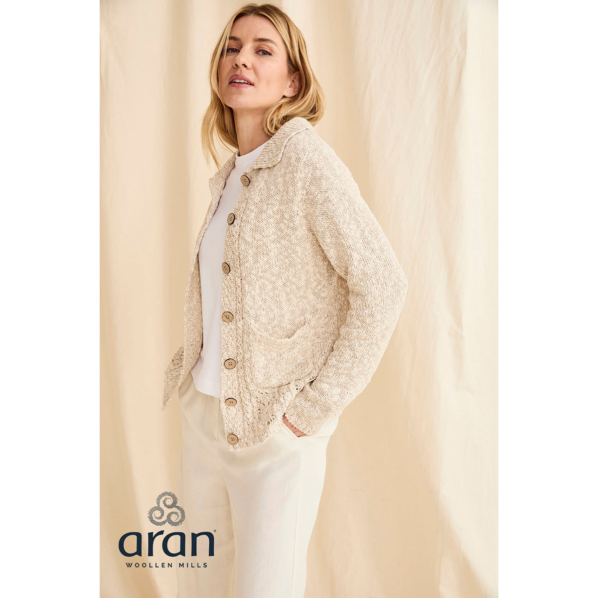 Cream cotton linen cardigan with wooden buttons and two patch pockets worn by a model