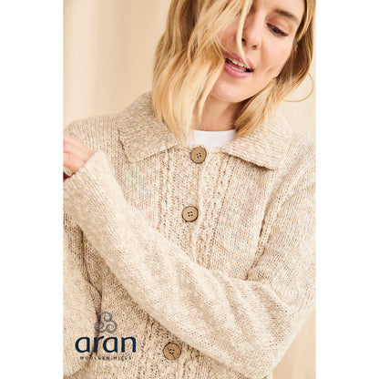 Close-up of the cream cardigan highlighting chunky knit texture and large wooden buttons at the chest