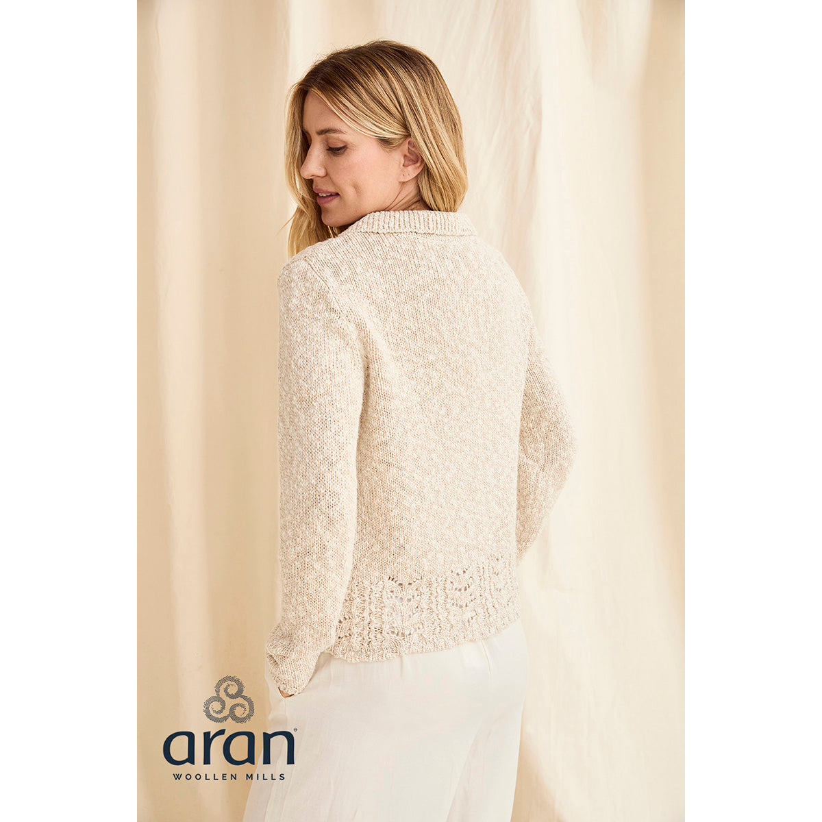 Side profile of cream knitted cardigan highlighting relaxed fit and crochet hem