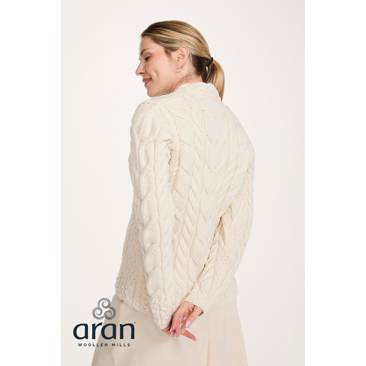 Back view of cream Tralee V-Neck merino sweater with cable knit on a model