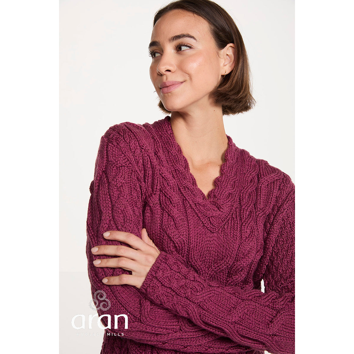 Close-up of the berry Tralee merino sweater highlighting the cable knit pattern and V-neck.