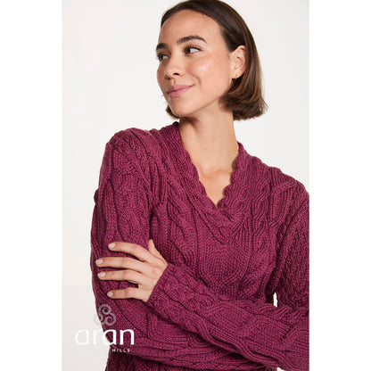 Close-up of the berry Tralee merino sweater highlighting the cable knit pattern and V-neck.