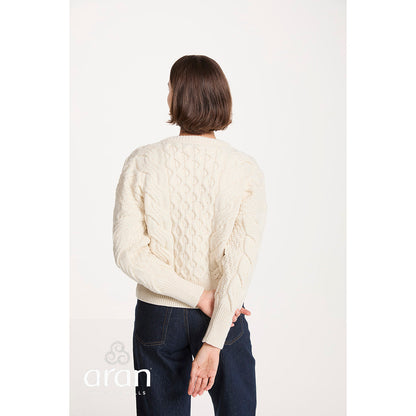 Back view of a model wearing a cropped beige cable knit jumper