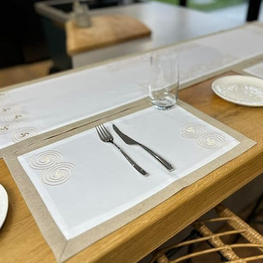 Table setting with fork, knife, glass, and decorative placemat on wooden table