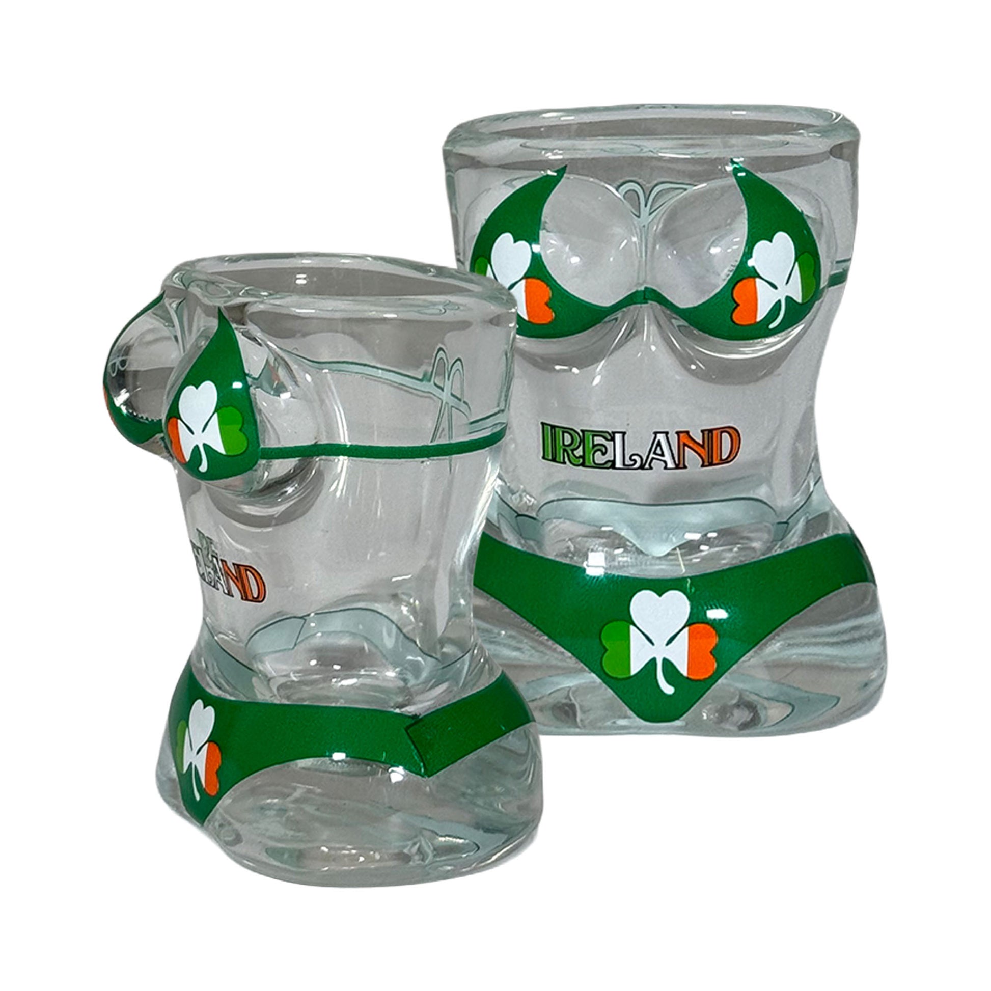 Two clear glass shot glasses shaped like torsos wearing green shamrock bikinis