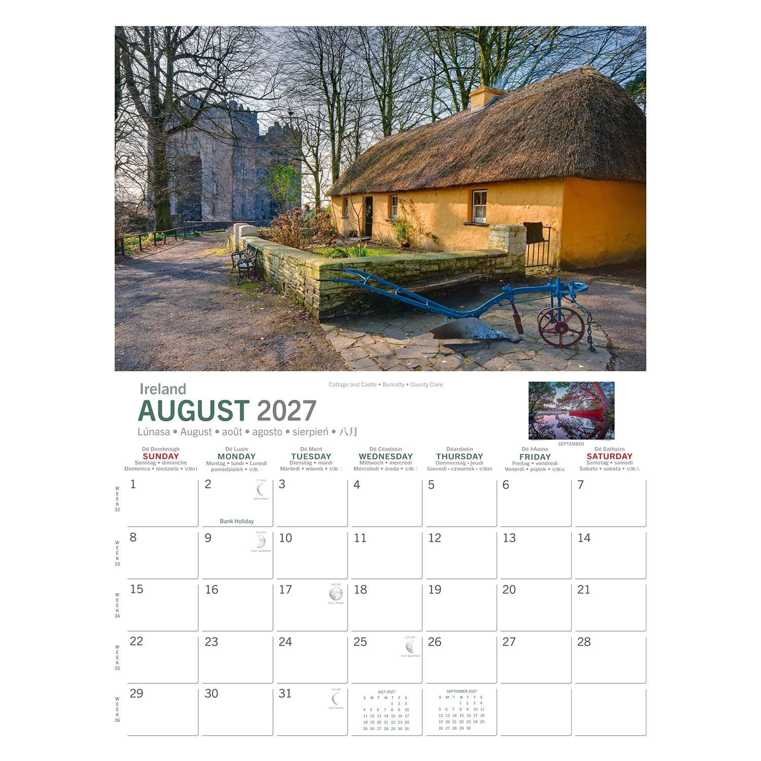Thatched yellow cottage with a stone wall and a blue farming implement in front.