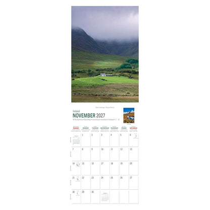 Vertical November 2027 calendar page showing a green valley, a white farm cottage, and misty mountains