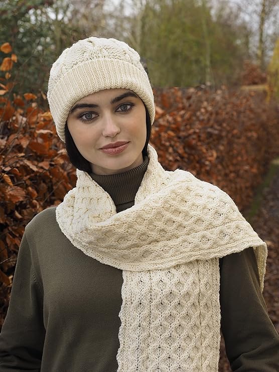 Woman wearing cream knit hat and matching scarf outdoors in autumn