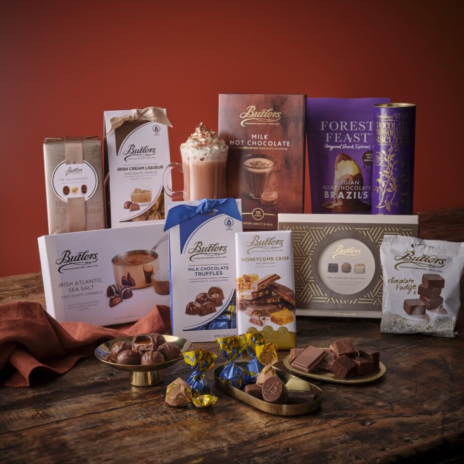 Assorted chocolates, hot chocolate, and festive treats arranged on wooden table
