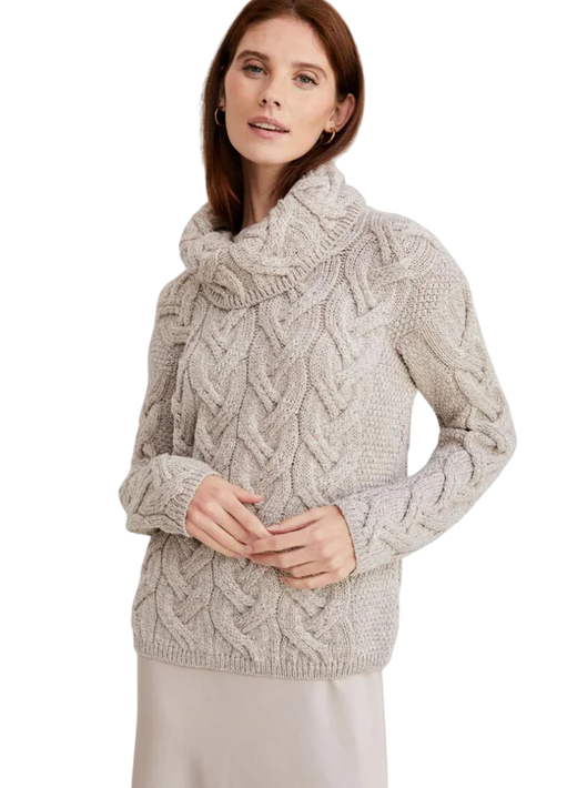 Woman wearing a beige cable knit turtleneck sweater with long sleeves