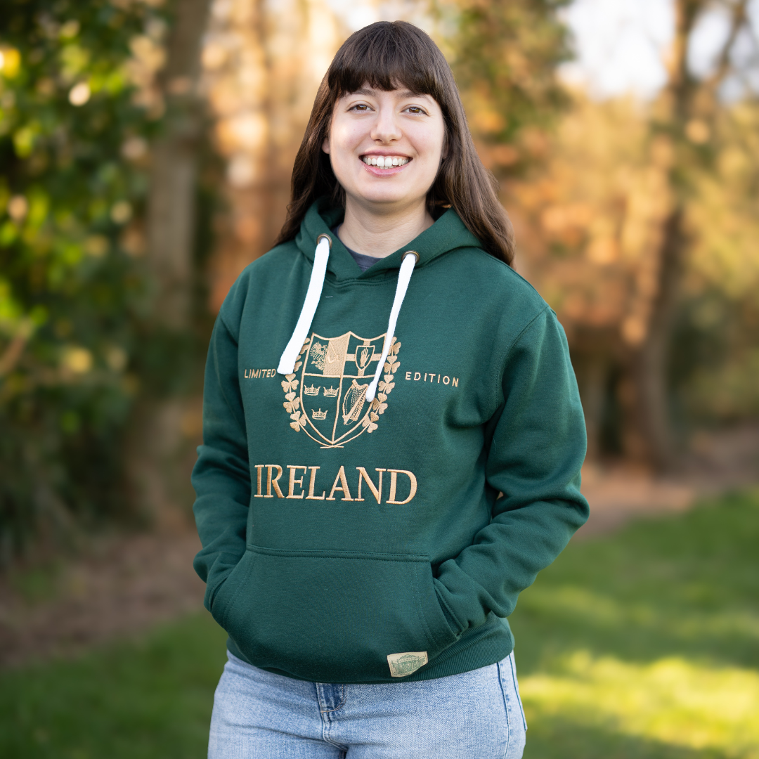 Smiling woman wearing green Ireland hoodie standing outdoors with hands in pockets