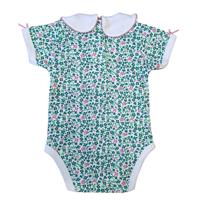Back view of a floral shamrock baby vest with white collars pink trim and small pink bows