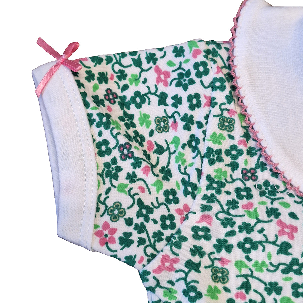 White baby vest with an allover shamrock floral print and a pink shoulder bow