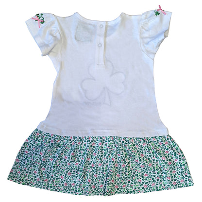 White kids dress with a floral green shamrock print skirt and pink ribbon details on the short sleeves
