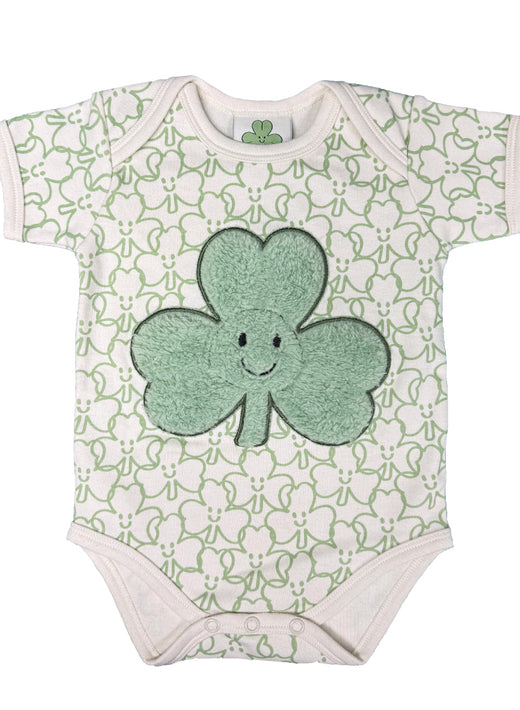 Front view of a plush baby vest with a mint shamrock applique on cream fabric and pale green all over pattern.