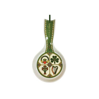 White spoon rest with a green handle displaying a circular panel of four Irish symbols the claddagh heart shamrock Celtic cross and harp