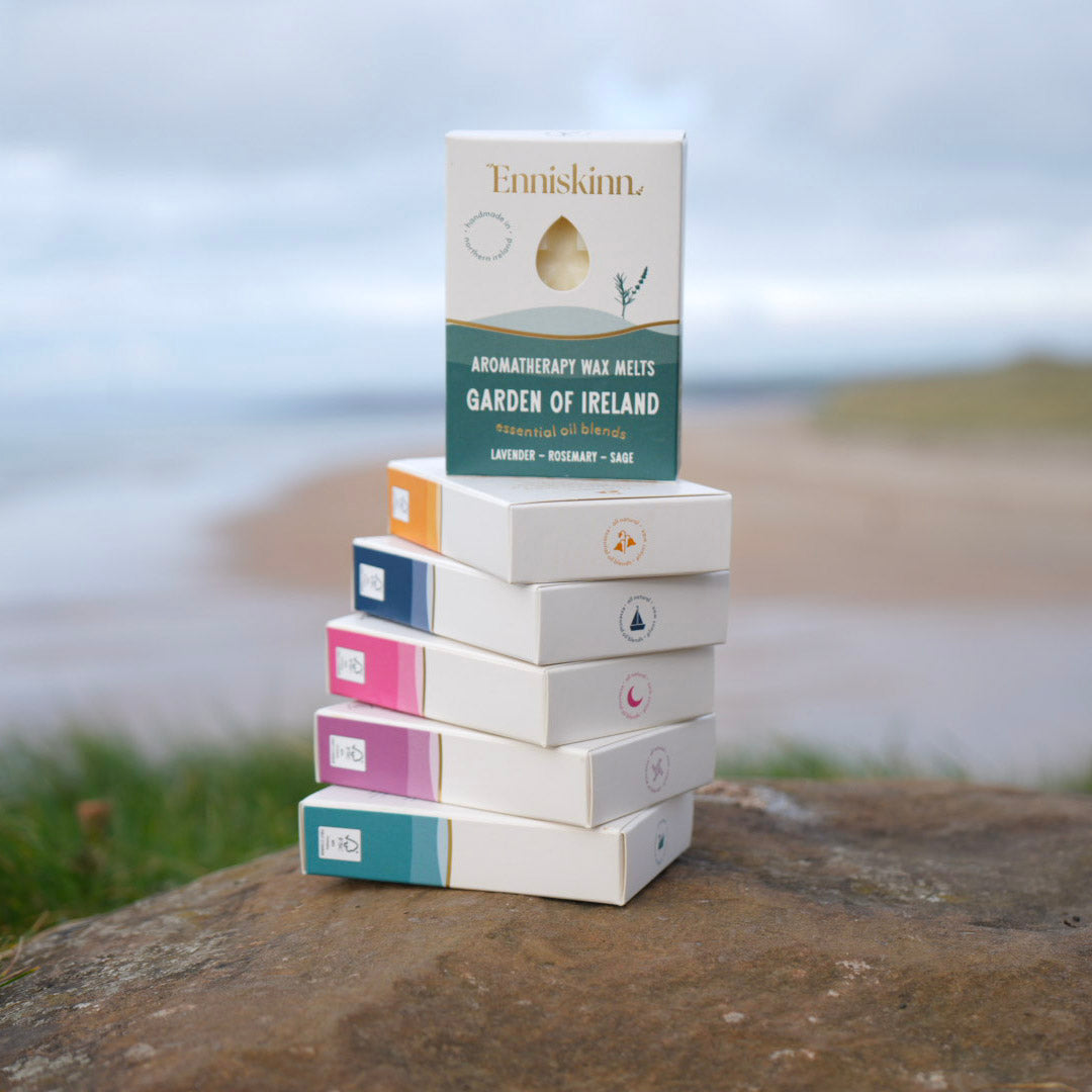 Garden of Ireland aromatherapy wax melts box perched on a stack of white boxes against a beachy backdrop