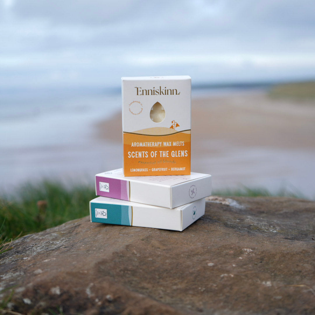 Enniskinn Aromatherapy Wax Melts Scents of the Glens box on a stack of pastel boxes outdoors near the coast.