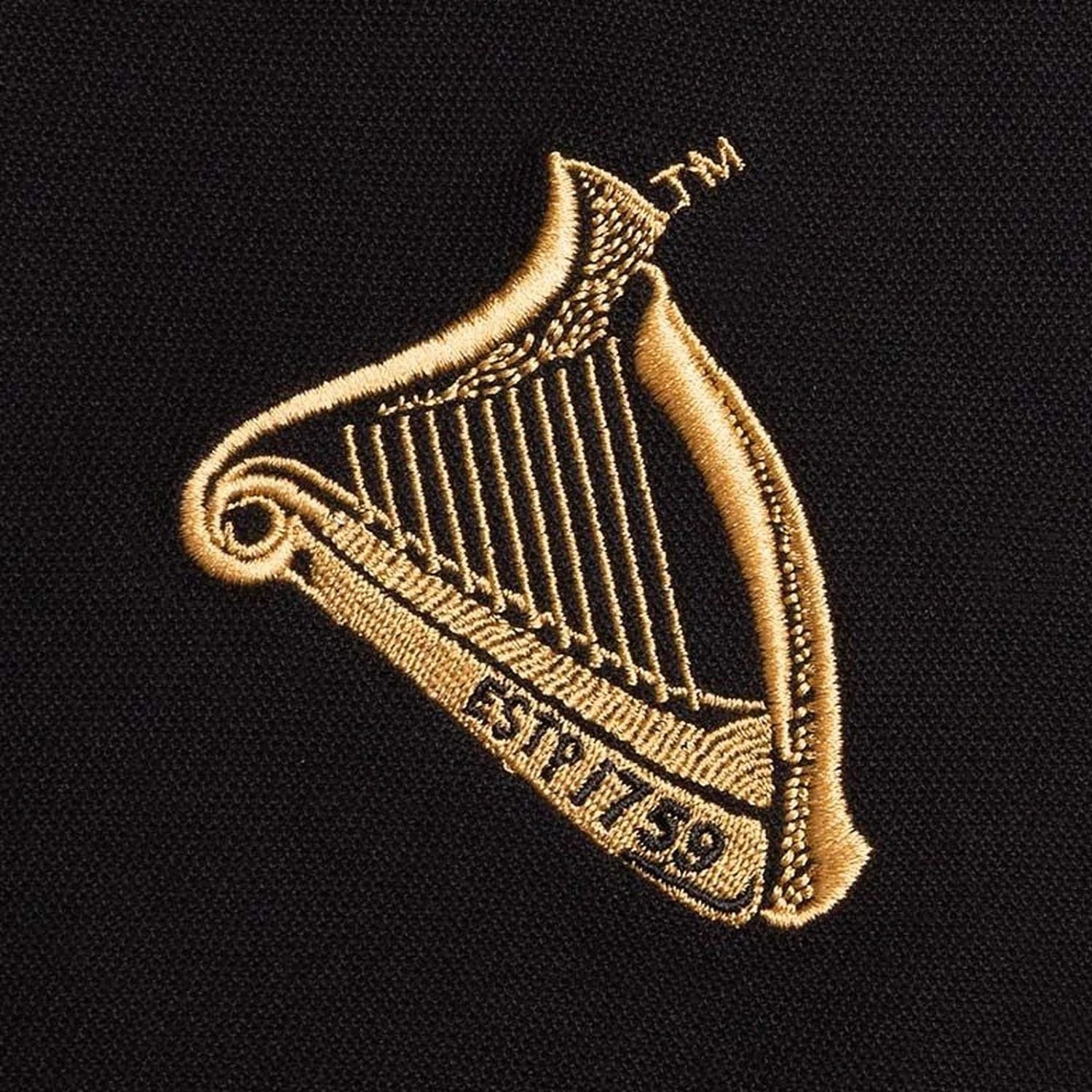 Gold embroidered harp crest on black polo fabric