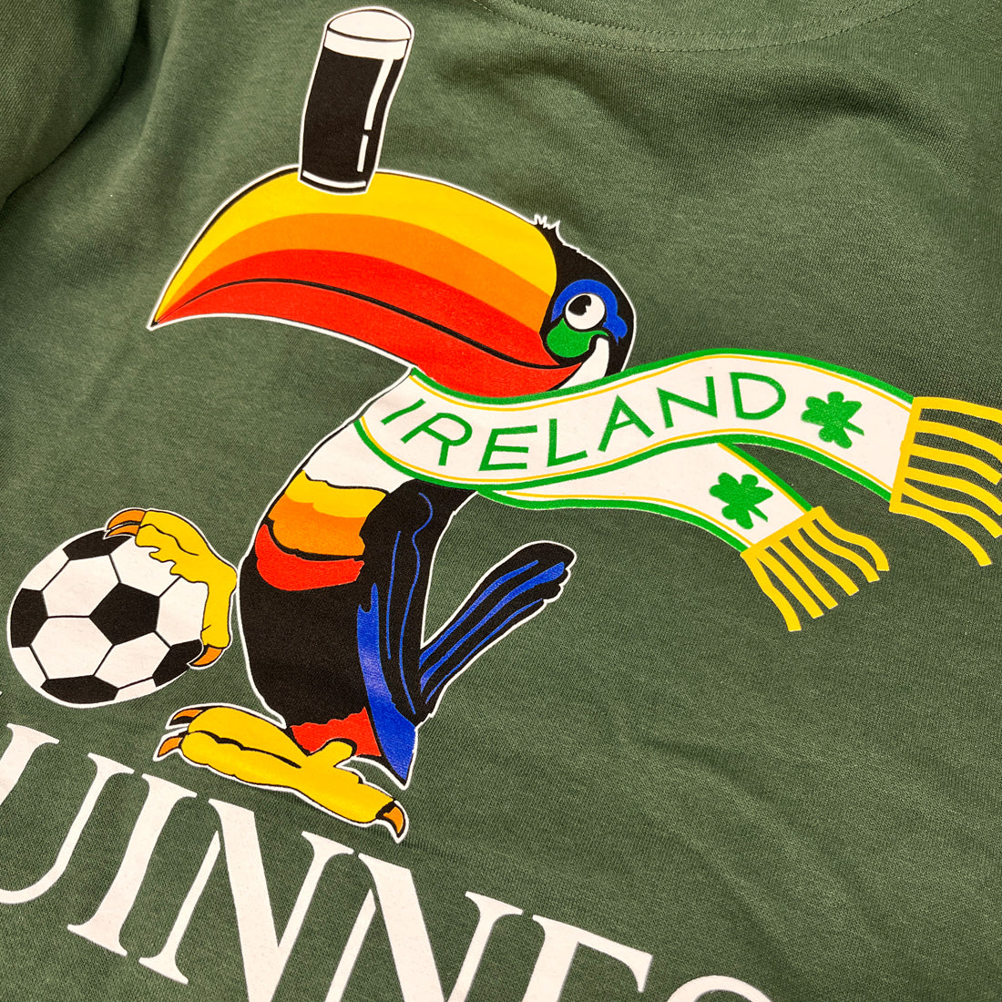 Colorful toucan mascot on a bottle green hoodie with an Ireland scarf and a football
