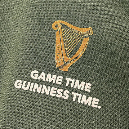Gold harp emblem with the words GAME TIME GUINNESS TIME on green fabric