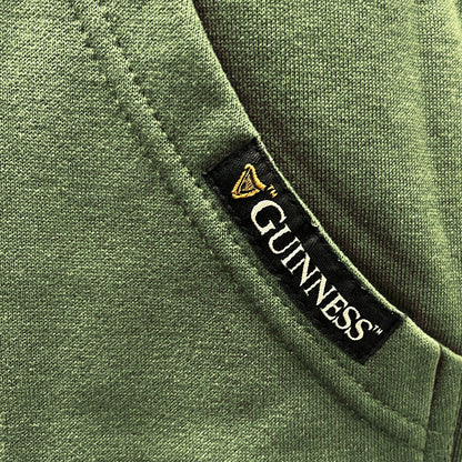 Black Guinness label tag sewn onto a green hoodie near the pocket