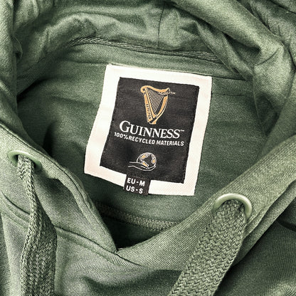 Guinness bottle green hoodie interior label featuring 100% recycled materials and size tag