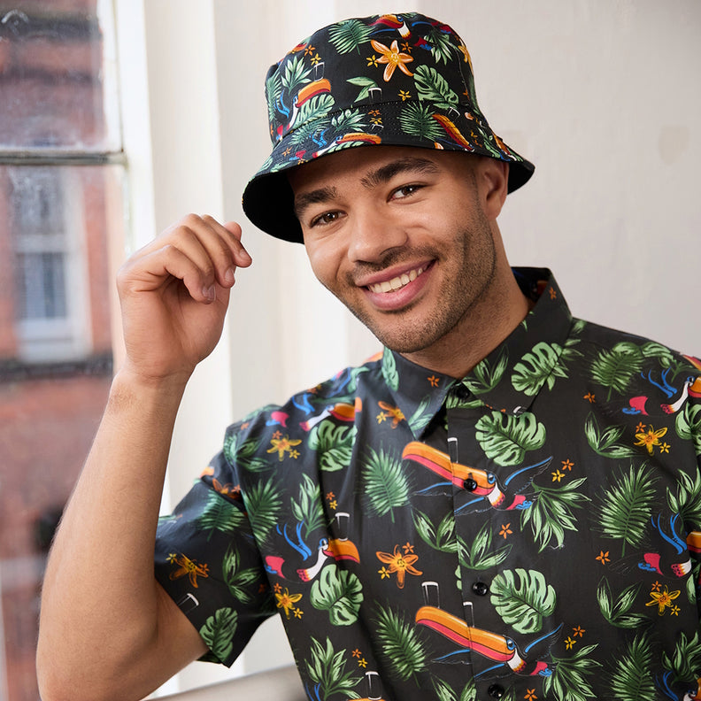 Smiling man wearing a tropical print bucket hat and matching shirt