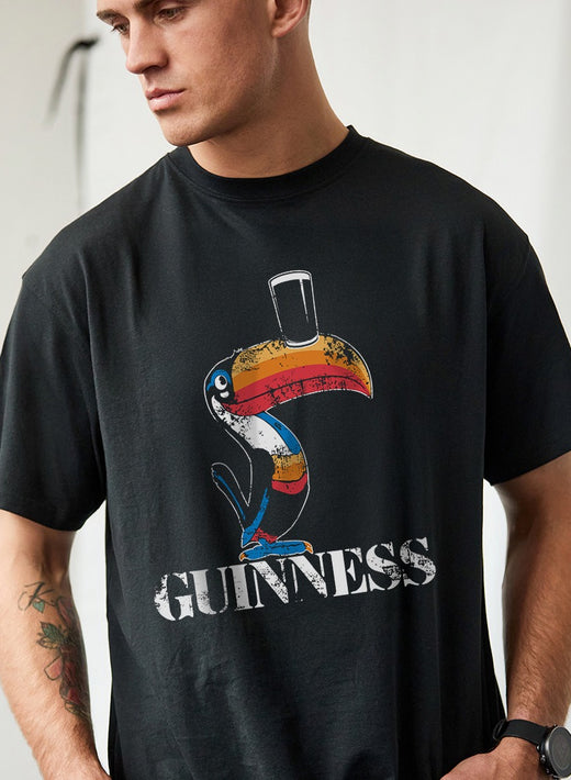 Man wearing black t-shirt with colorful toucan and text design