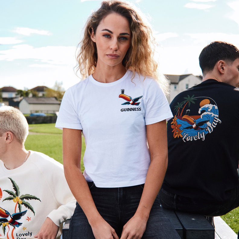 White Guinness T shirt with a small chest logo worn by a woman outdoors