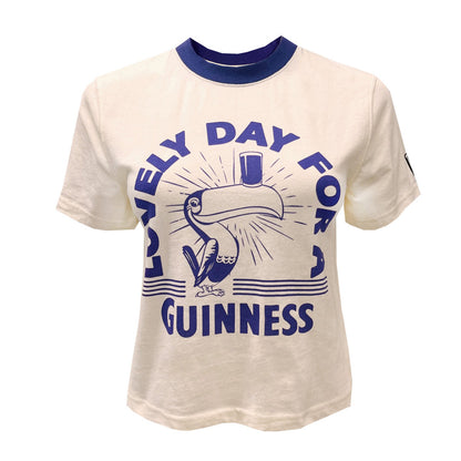 Cream cropped T shirt featuring a blue toucan graphic and bold Guinness lettering across the front.