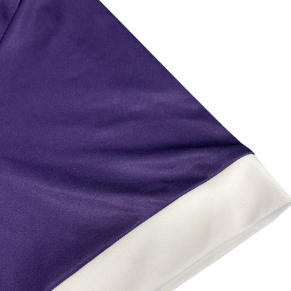 Close-up of purple jersey with white hem along the sleeve.