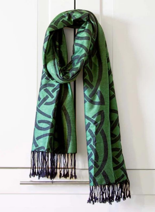 Green scarf with black Celtic knot pattern hanging on white cabinet