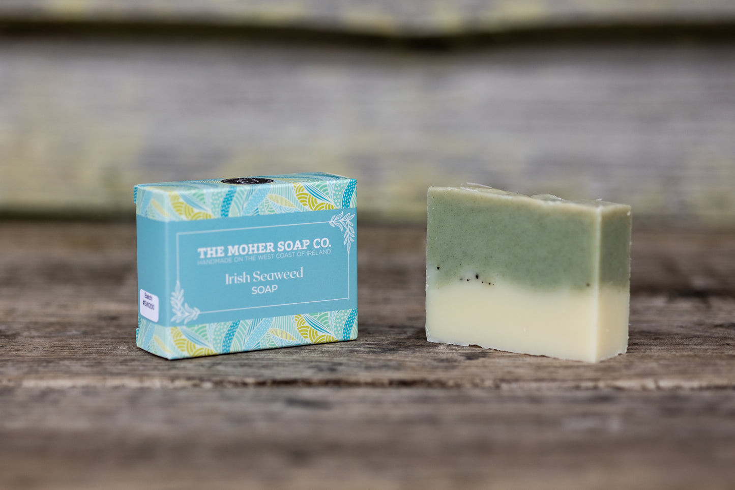Irish Seaweed Soap bar with green and cream layers beside The Moher Soap Co blue packaging