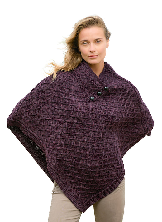 Model wearing NUA Plum Super Soft Merino Poncho with a lattice knit and a pointed hem