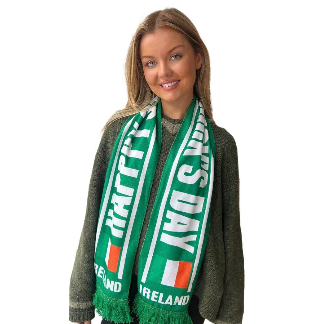 Smiling woman wearing green sweater and Happy St. Patrick's Day scarf