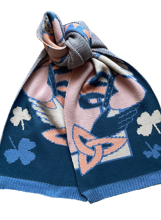 Close up of Claddagh Blue and Salmon Knit Scarf showing a navy base with peach and cream floral motifs and a blue ribbed hem