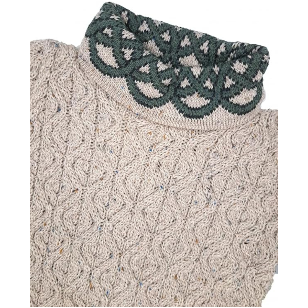 Close-up of beige knitted sweater with green patterned turtleneck collar