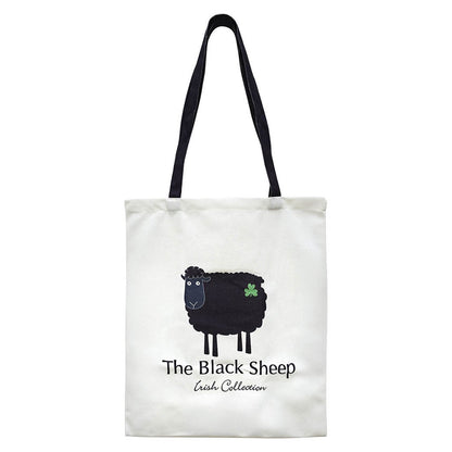 White tote bag featuring a black sheep graphic and shamrock with dark navy handles